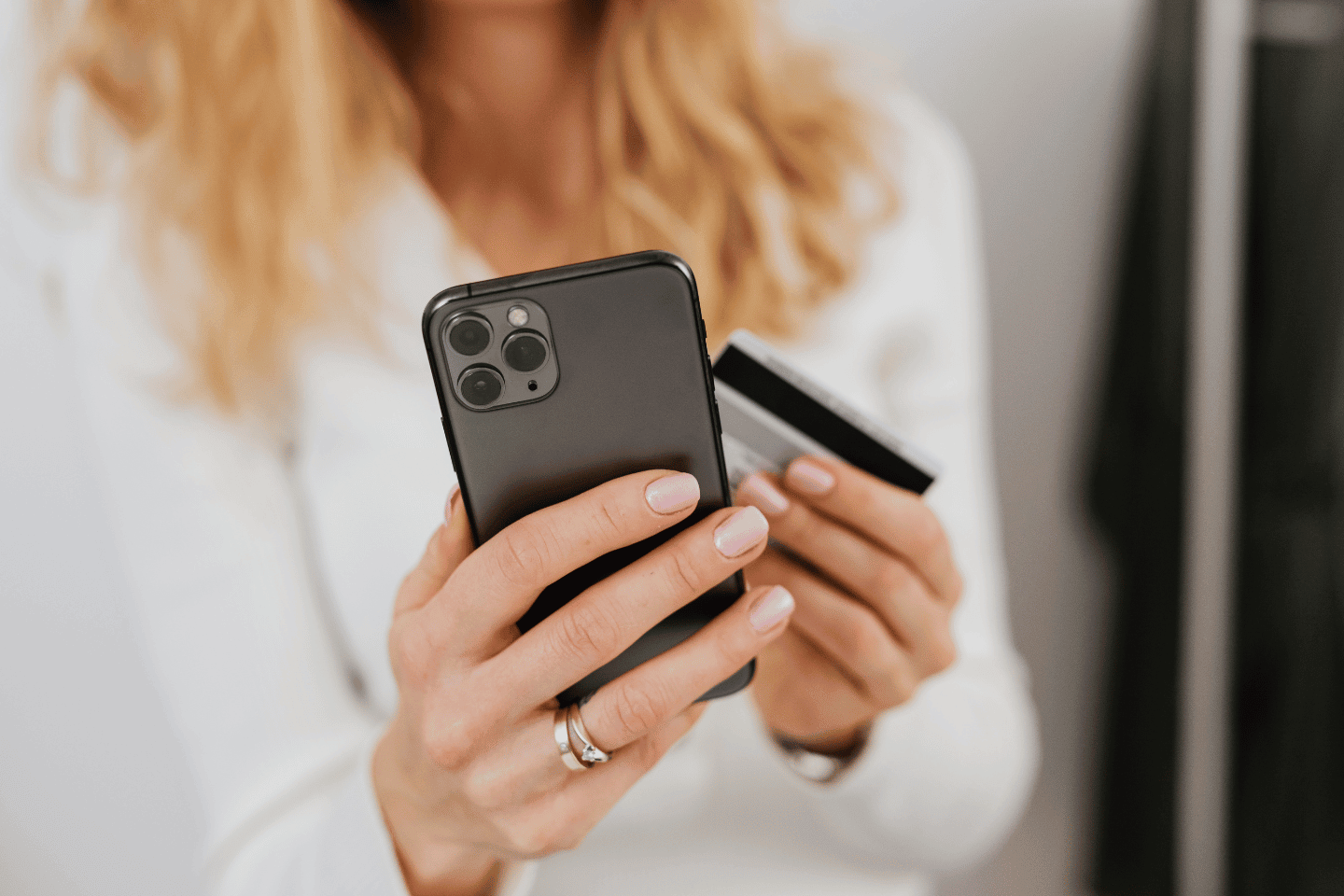A women holding a mobile with a credit card in her hand